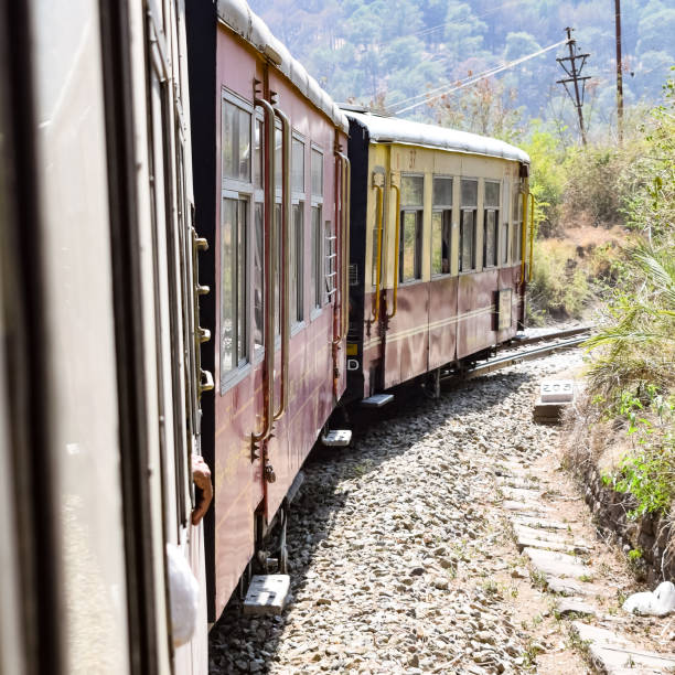 istock Toy Train moving on mountain slopes, beautiful view, one side mountain, one side valley moving on railway to the hill, among green natural forest. Toy train from Kalka to Shimla in India 1400366550