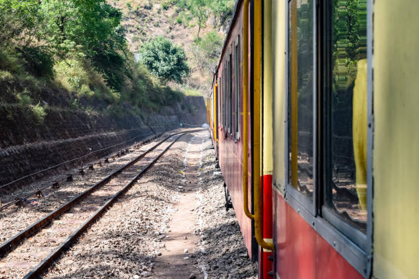 istock Toy Train moving on mountain slopes, beautiful view, one side mountain, one side valley moving on railway to the hill, among green natural forest. Toy train from Kalka to Shimla in India 1400366551