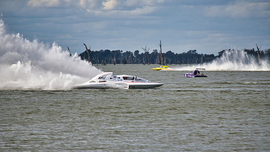 Mulwala, New South Wales Australia - March 28, 2021: White and yellow hydroplanes racing on Lake Mulwala NSW Australia