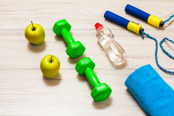istock Towel and different tools for fitness on floor in room. 1400368732