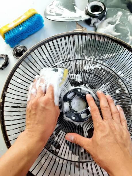 istock Hand Cleaning Dusty Electric fan parts. 1400369621
