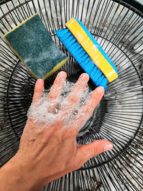 istock Detergent foam on hand cleaning electric fan part. 1400370377
