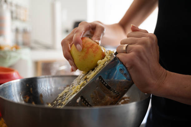Closeup view of a woman grating an apple for apple stock photo