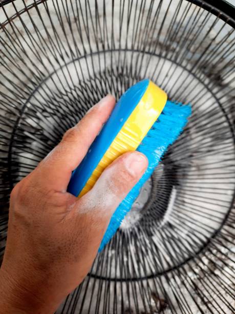 istock Hand holding Brush with foam - cleaning electric fan. 1400371409