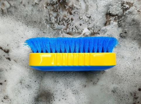 Cleaning Brush - dirty and dusty detergent foam background.