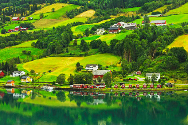 A village Olden surrounded by green forested mountains in Norway.