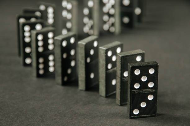 istock Black dominoes chain on dark table background 1400374182