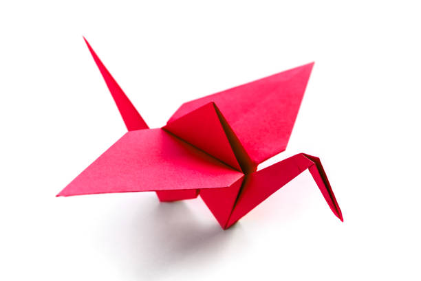 Origami art. Handmade paper crane on orange background, closeup