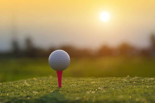 istock Golf ball on tee in beautiful golf course at sunset background. 1400376178