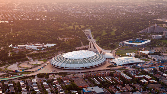Montreal, CA / USA - August 07, 2019: Aerial view of Olympic Stadium in Montreal, Quebec, Canada.\n\nOlympic Stadium is a multi-purpose stadium in Montreal, Canada, located at Olympic Park in the Hochelaga-Maisonneuve district of the city. Montreal Olympic Stadium was built in the 1970s to serve as the flagship venue of the 1976 Summer Olympics.