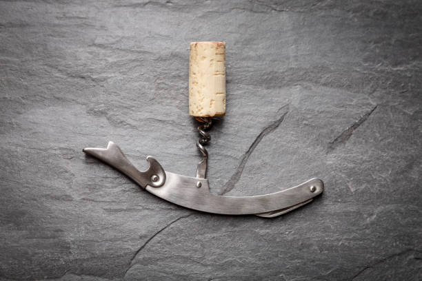istock Stainless  wine corkscrew with a cork on a black rocky slate background 1400382601