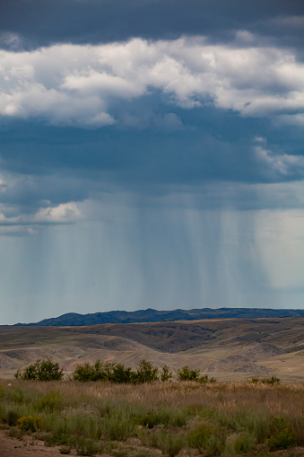 Storm cloud and rain over the mountains panorama. Kazakhstan, Almaty province.