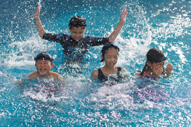 Kids splashing in pool stock photo