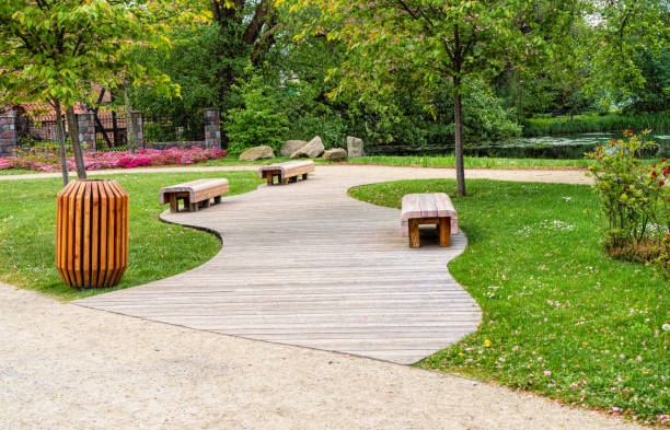 istock Wooden garden bench in fresh green spring park 1400387543