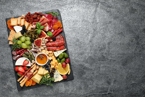 Set of different delicious appetizers served on grey table, top view. Space for text