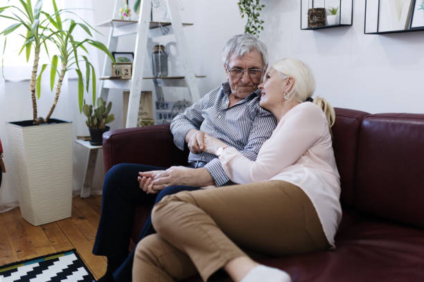 istock Loving senior couple embracing at home on sofa 1400392244