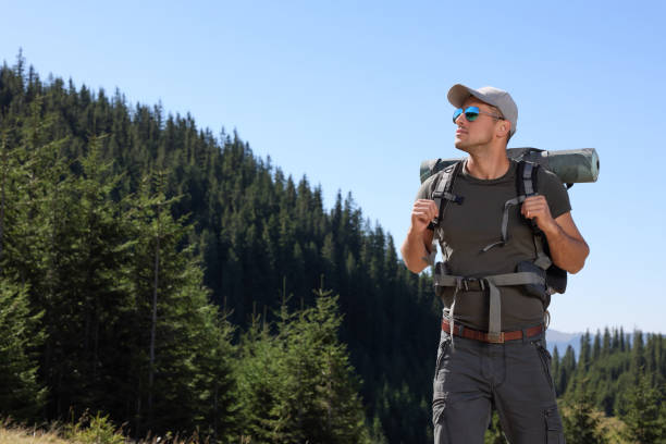 istock Man with backpack and sleeping mat in mountains. Space for text 1400392550