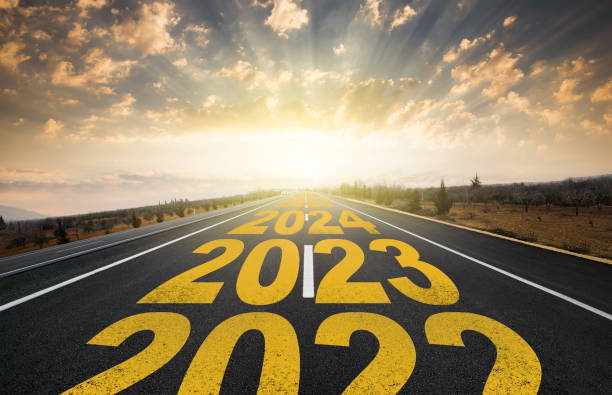 New year 2023 concept The word 2023 written on highway road in the middle of empty asphalt road at golden sunrise. New year 2023 concept. Concept of planning and challenge, business strategy, new life change 2023 photos stock pictures, royalty-free photos & images