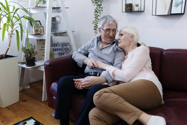 istock Loving senior couple embracing at home on sofa 1400392670