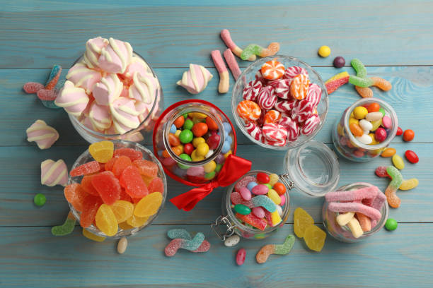 istock Jars with different delicious candies on light blue wooden table, flat lay 1400392740