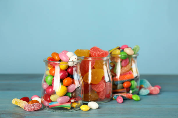 istock Jars with different delicious candies on turquoise wooden table 1400392905