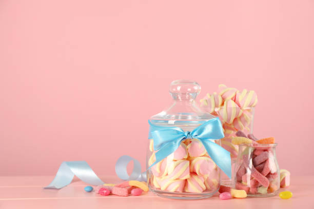 istock Jars with different delicious candies on pink wooden table, space for text 1400393023