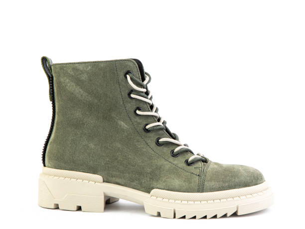 istock Green suede boots with white laces and zipper on the side. Elasticated side details and white rubber sole. Isolated close-up on white background 1400393265