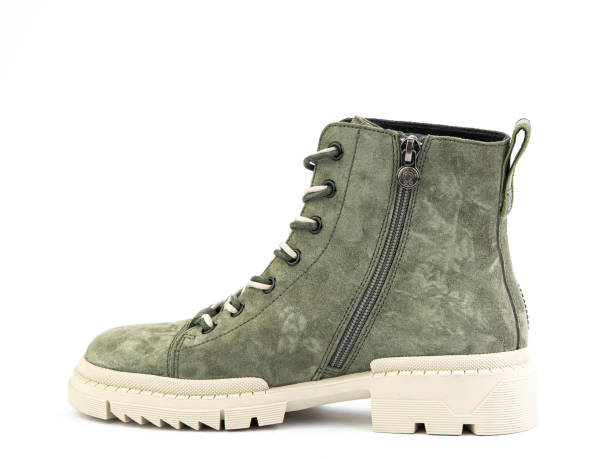 istock Green suede boots with white laces and zipper on the side. Elasticated side details and white rubber sole. Isolated close-up on white background 1400393277