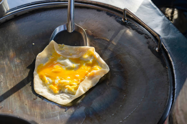 istock Roti with eggs being fried in a pan in the light of the sun. 1400394424