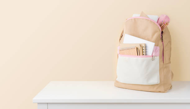 istock Stylish backpack with school stationery on table against beige background 1400395801