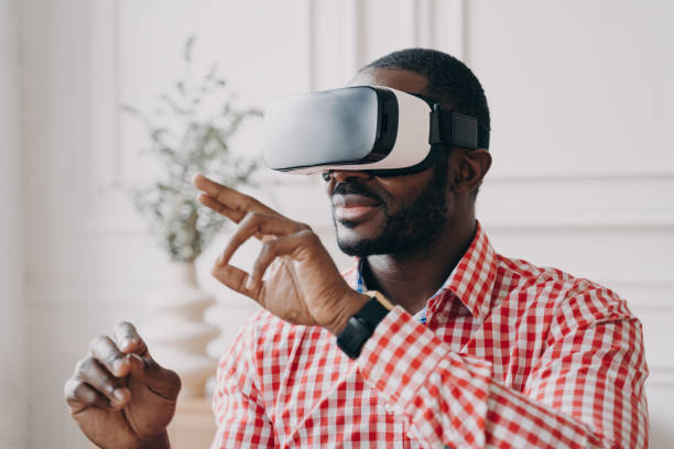 istock Young african businessman wearing VR glasses touching 3d objects, interacting with virtual reality 1400396212