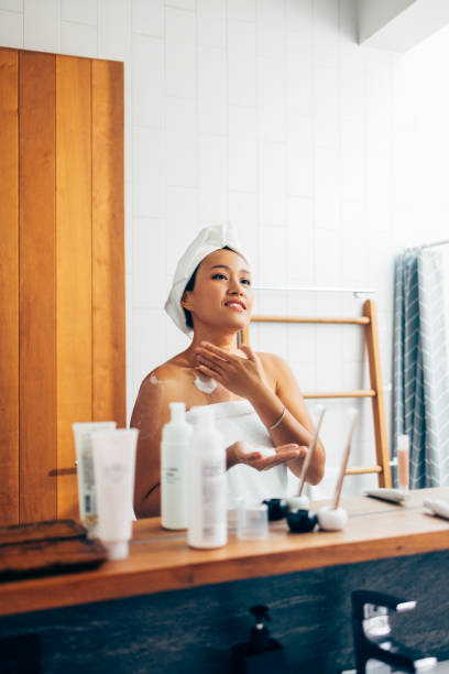 istock Asian Woman Applying Cream In The Mirror 1400400395