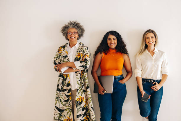 istock Three diverse businesswomen standing against an office wall 1400400631