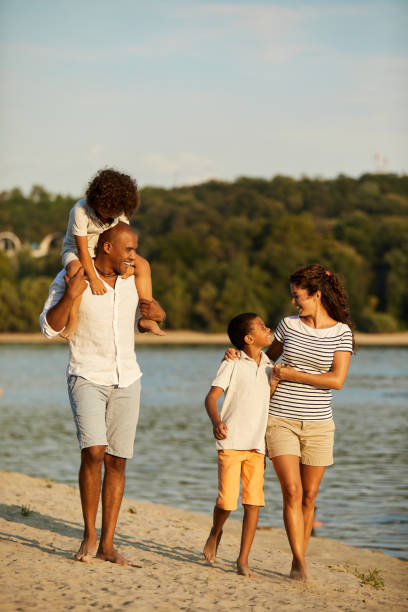 Beautiful family walking on the beach stock photo
