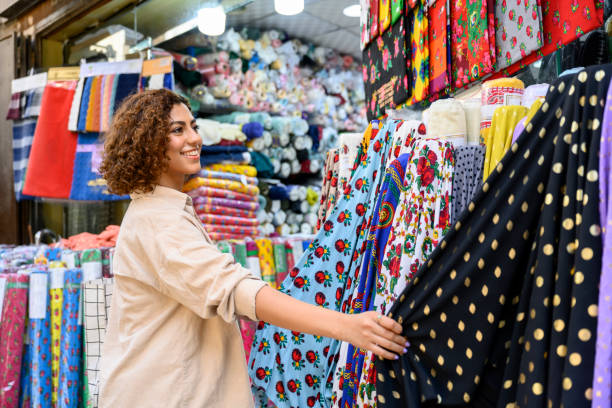 Young Saudi woman shopping for fabric at Jeddah bazaar