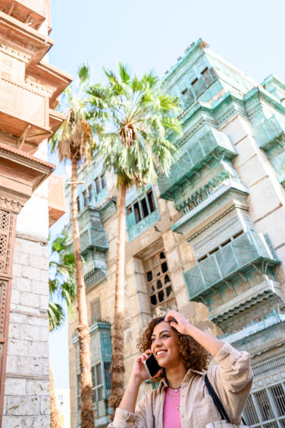istock Middle Eastern woman walking and using phone in Jeddah 1400404224