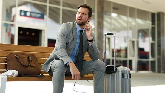 Pensive businessman is waiting at train station alone