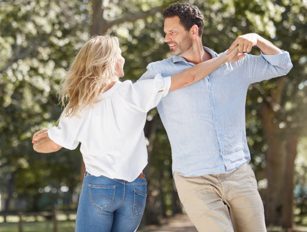 istock Loving young couple having romantic moment while sharing a dance and spending together in the backyard. Happy caucasian lovers being playful and enjoying time outdoors in a garden 1400406736