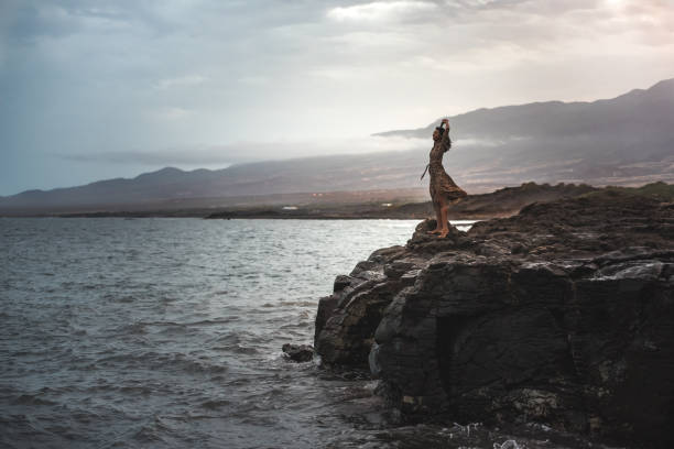 istock Woman standing in a cliff seashore 1400407878