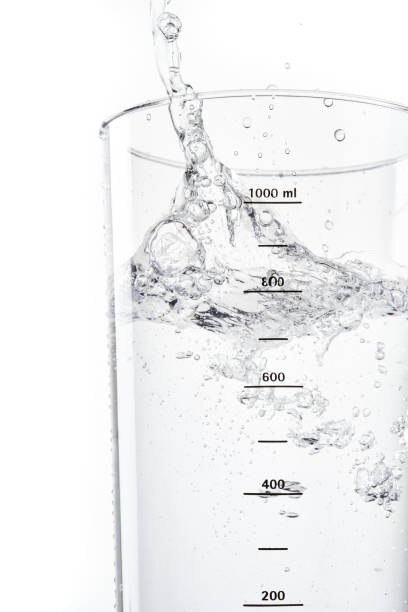 istock Pouring water into glass on white background. 1400412291