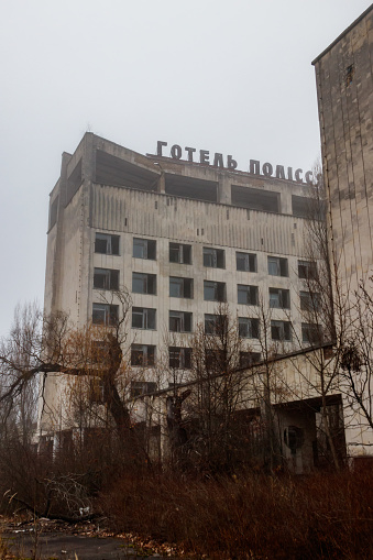 Pripyat, Ukraine - November 13, 2021: Abandoned building of Polissya hotel in the ghost town Pripyat in Chernobyl Exclusion Zone, Ukraine. Inscription in Ukrainian: Hotel Polissya