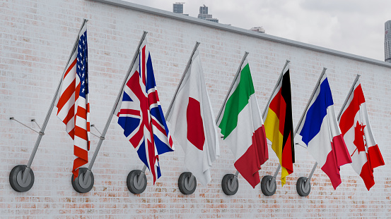 G7 table flags, 3d render. Flags of Group of Seven around podium, countries:  Canada, France, Germany, Italy, Japan, the United Kingdom, USA.