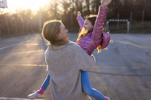 Embraced Caucasian mother and daughter enjoy the spring day together