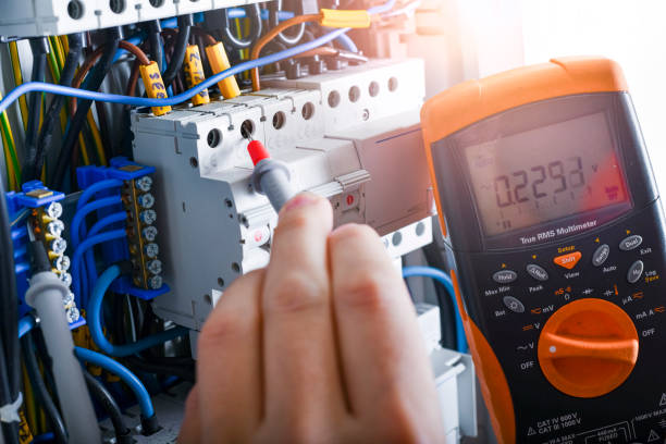 istock Electrician installing electric cable wires of fuse switch box. 1400420911