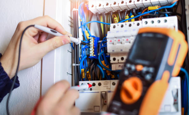 istock Electrician installing electric cable wires of fuse switch box. 1400420920