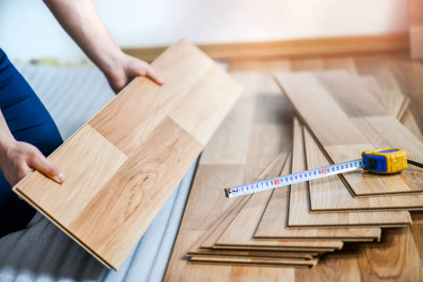 istock Worker hands installing timber laminate floor in modern house. Wooden floors renovation 1400420934