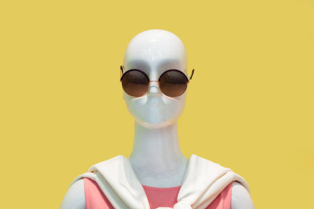 Mannequin wearing sunglasses against yellow background