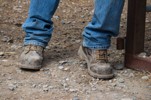 istock Pair of work boots standing with legs apart 1400425227