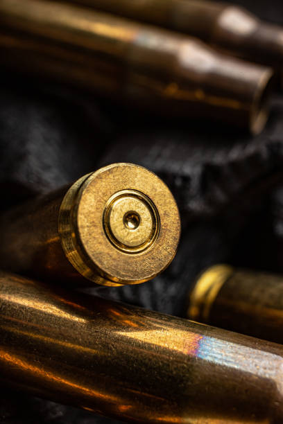 istock Empty shells from weapons on black smoldering coals. Consequences of the war. Dark background. 1400425759