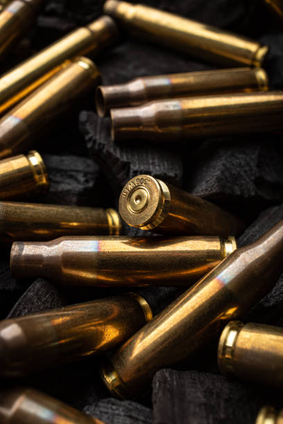 istock Empty shells from weapons on black smoldering coals. Consequences of the war. Dark background. 1400425763